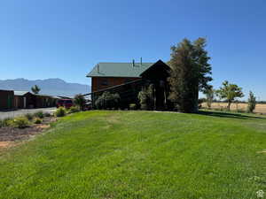 View of front facade with a front lawn, a mountain view, and metal roof