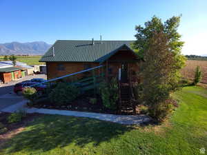 View of front of home featuring stairway, a front lawn, metal roof, and a mountain view