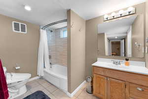 Full bath featuring toilet, baseboards, vanity, shower / tub combo, and tile patterned flooring