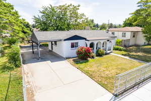 Ranch-style home with driveway, roof with shingles, covered porch, a carport, and a chimney