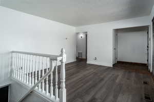 Unfurnished room featuring dark wood-style floors and baseboards