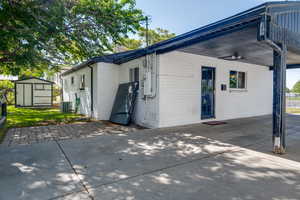 Back of house with a patio area, brick siding, an attached carport, and cooling unit