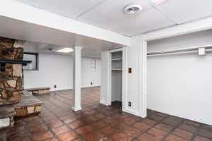 Finished basement featuring a drop ceiling and tile patterned flooring