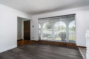Unfurnished dining area featuring wood finished floors and baseboards