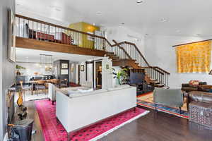 Living room featuring stairway, wood finished floors, a towering ceiling, and recessed lighting
