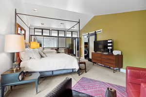 Carpeted bedroom featuring a barn door, lofted ceiling, baseboards, and recessed lighting