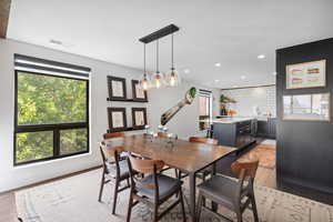 Dining room featuring healthy amount of natural light, light wood-style flooring, recessed lighting, and a chandelier