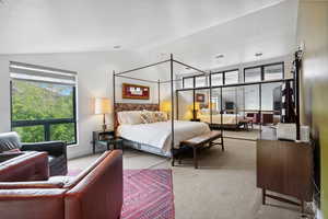 Carpeted bedroom featuring vaulted ceiling