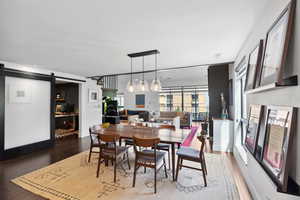 Dining space with wood-type flooring and a barn door
