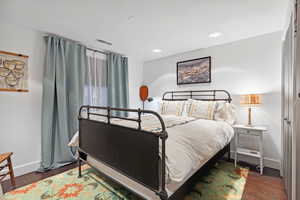 Bedroom featuring baseboards, wood finished floors, and recessed lighting