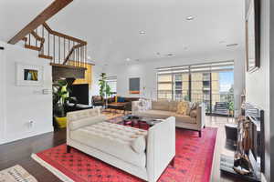 Living room with recessed lighting, wood-type flooring, a fireplace, and stairway