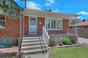 View of front of home featuring brick siding and covered porch