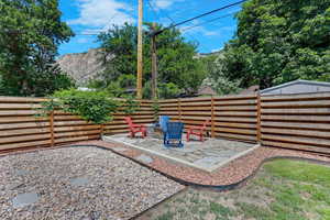 Fenced backyard with a patio area and an outdoor fire pit