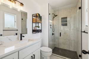Pimary Bathroom featuring vanity, toilet, a stall shower, and marble tiles