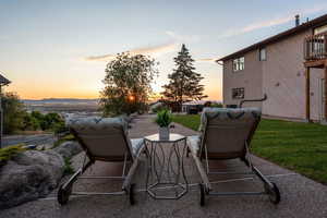 Patio terrace at dusk featuring a yard