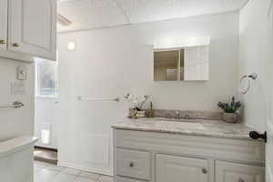 Bathroom featuring vanity, toilet, and tile patterned floors, and a walkout to the backyard