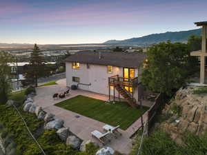 Rear view of property featuring a patio, stairs, a deck with mountain and valley view, a yard, and an outdoor fire pit