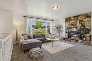 Living room featuring carpet, a fireplace, and bay windows