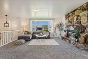 Living area featuring carpet flooring, a fireplace, and bay windows