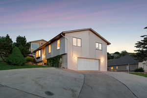 Property exterior at dusk featuring driveway and a garage