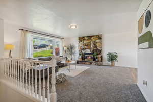Carpeted living area featuring a fireplace, and bay windows