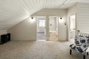 Additional living space featuring lofted ceiling, carpet, wooden walls, and wood ceiling