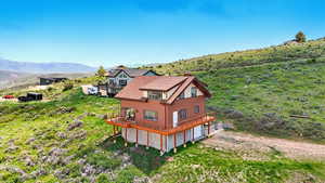 Aerial view of property and surrounding area featuring a mountain backdrop