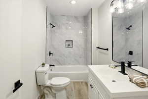 Full bathroom with toilet, vanity, and shower / bath combination