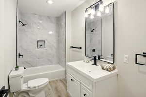 Full bathroom featuring toilet, wood finished floors, vanity, and shower / bath combination