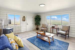 Living area with a wood stove, light wood-type flooring, and ornamental molding