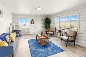 Living area featuring a wood stove, light wood-style flooring, and healthy amount of natural light