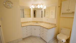Bathroom featuring toilet, vanity, and tile patterned flooring