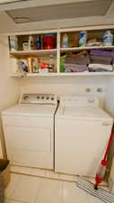 Laundry area featuring separate washer and dryer and tile patterned floors