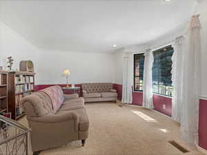Carpeted living room featuring crown molding