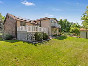 Rear view of house featuring a deck and brick siding