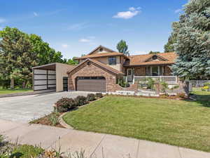 Tri-level home featuring brick siding, concrete driveway, covered porch, and an attached garage