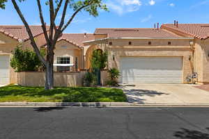Mediterranean / spanish-style house with stucco siding, a tile roof, driveway, and an attached garage