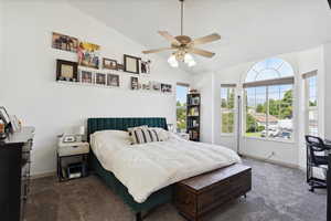 Bedroom featuring carpet flooring, vaulted ceiling, baseboards, and ceiling fan