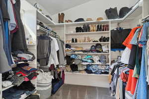 Walk in closet featuring carpet flooring and vaulted ceiling