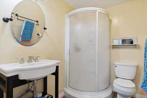 Bathroom with a shower stall, toilet, and baseboards