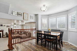 Dining space featuring wood finished floors, ceiling fan, healthy amount of natural light, a textured ceiling, and baseboards