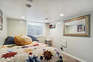 Bedroom featuring carpet floors, baseboards, a textured ceiling, and recessed lighting