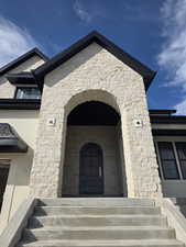 Natural stone entry with arched iron door.