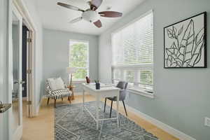 Office area with a ceiling fan, light wood finished floors, and baseboards