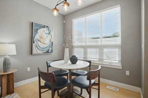 Dining room with baseboards, healthy amount of natural light, and light wood-style flooring