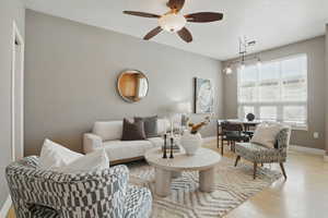 Living area featuring ceiling fan, light wood-style floors, and baseboards