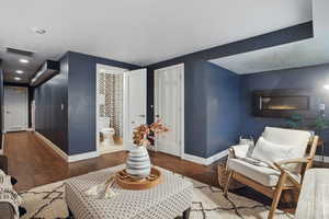 Living area with baseboards and wood finished floors