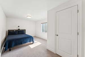 Bedroom featuring light colored carpet and baseboards