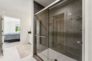Bathroom with a stall shower, connected bathroom, tile patterned floors, and vanity