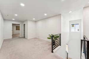 Hallway featuring an upstairs landing, recessed lighting, baseboards, and carpet